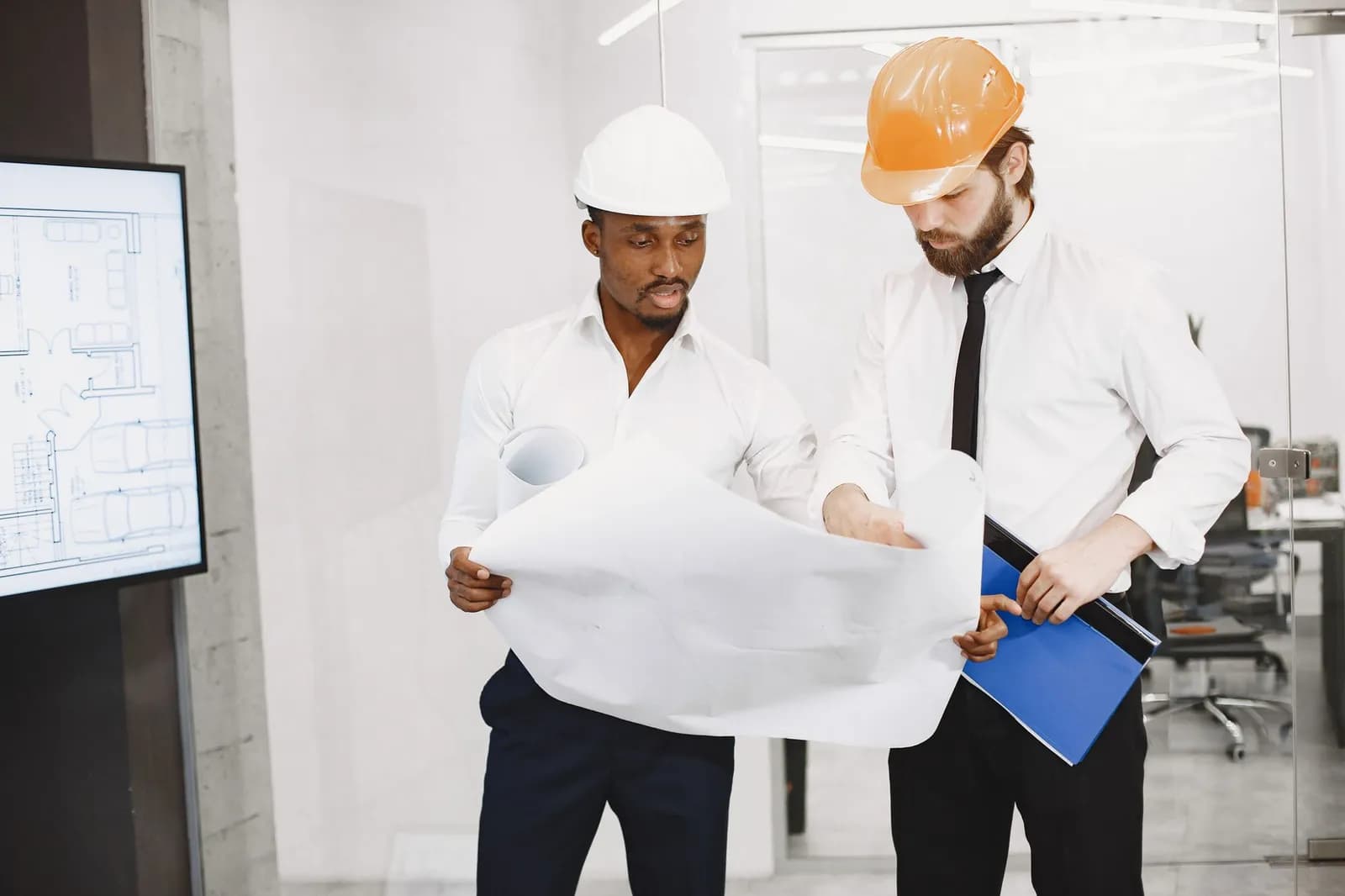 Ingénieurs étudiant des plans techniques en réunion
