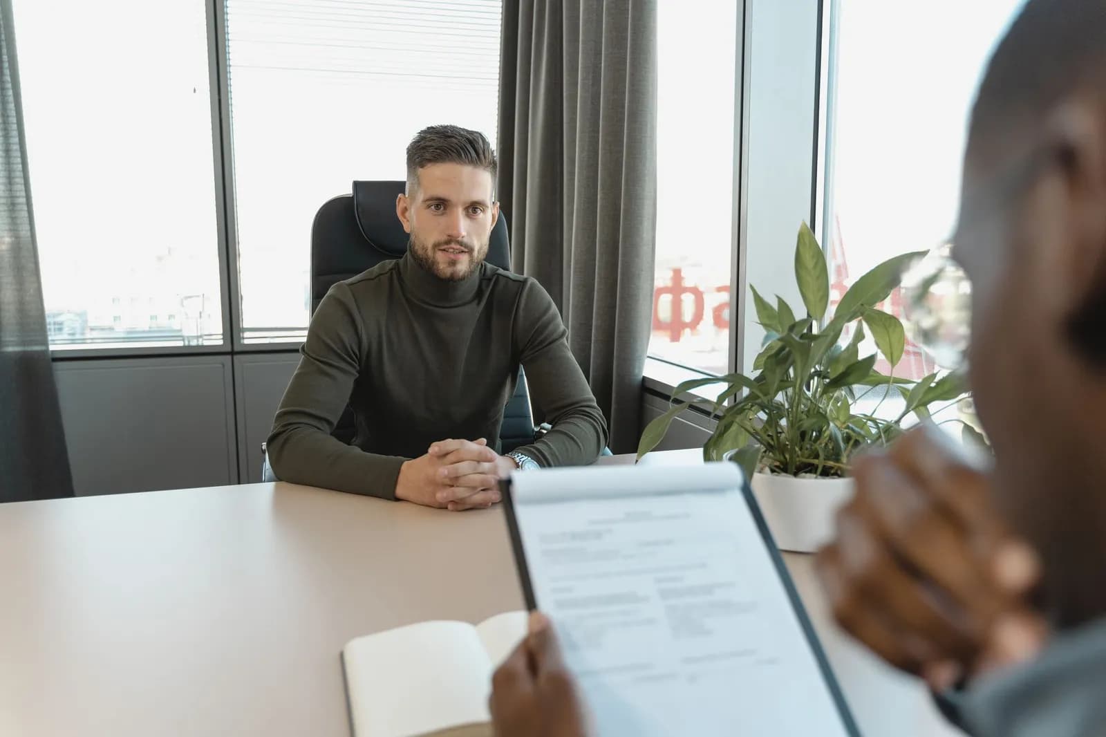 Entretien de recrutement dans un cabinet, candidat présentant son CV