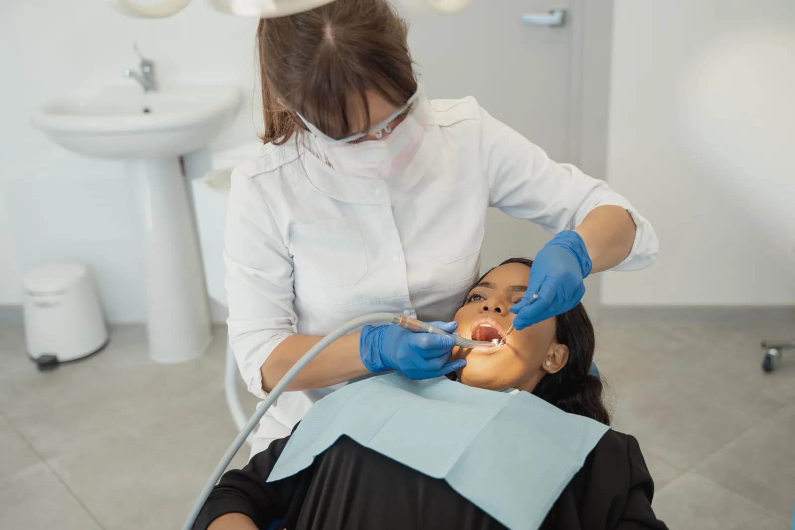 Chirurgien-dentiste examinant un patient au fauteuil