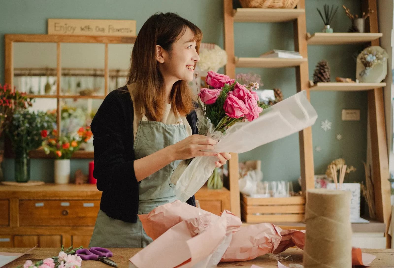 Fleuriste composant un bouquet dans sa boutique