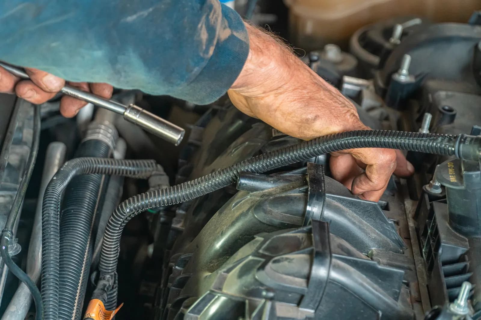 Mécanicien réparant le moteur d'une voiture au garage