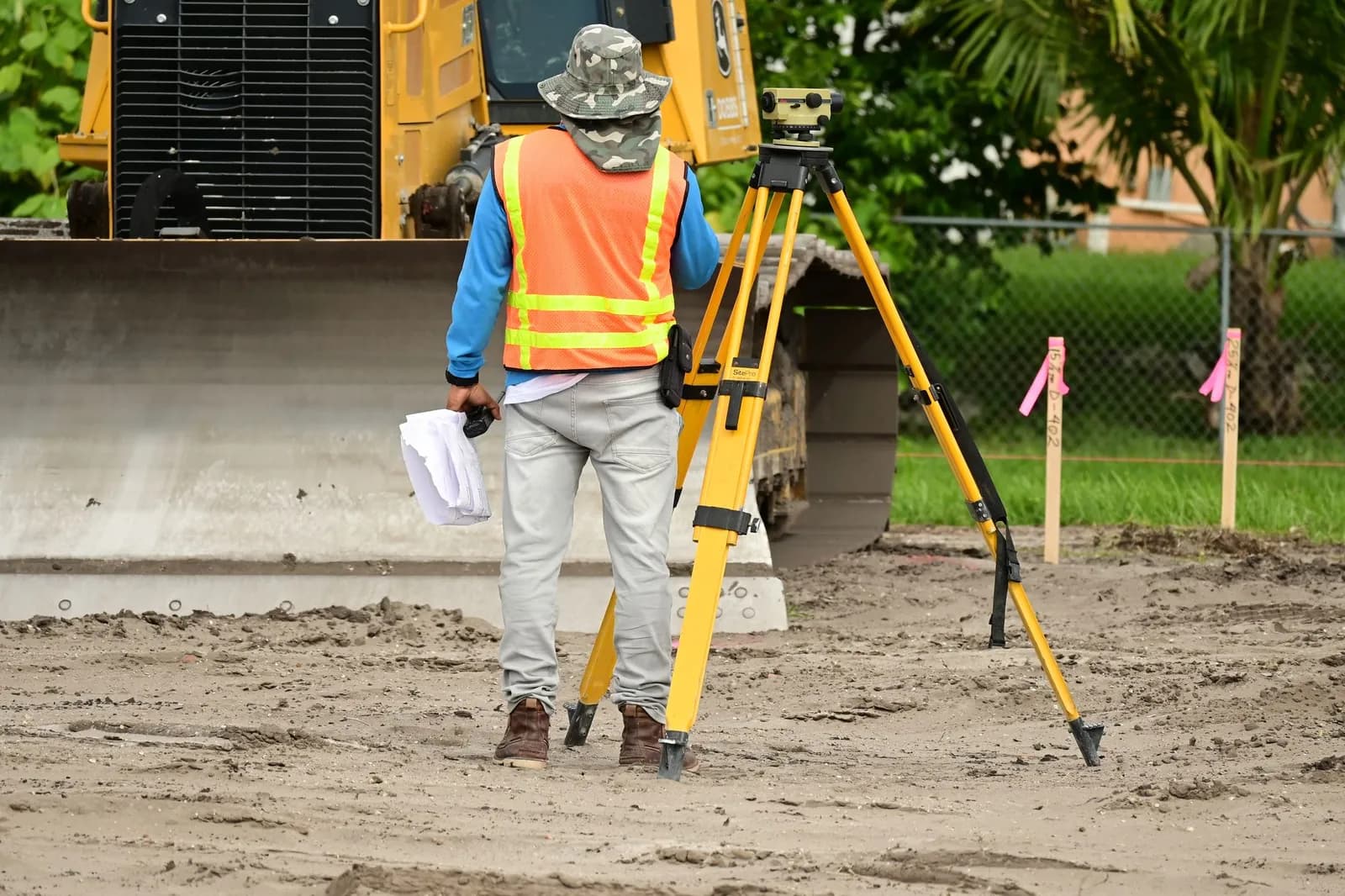 Géomètre-expert réalisant un relevé sur le terrain avec une station totale