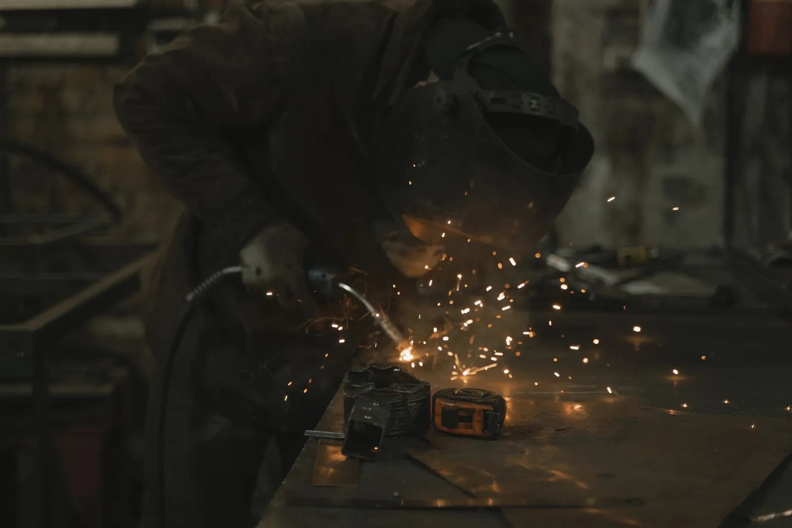 Métallier au travail dans son atelier, gerbe d'étincelles